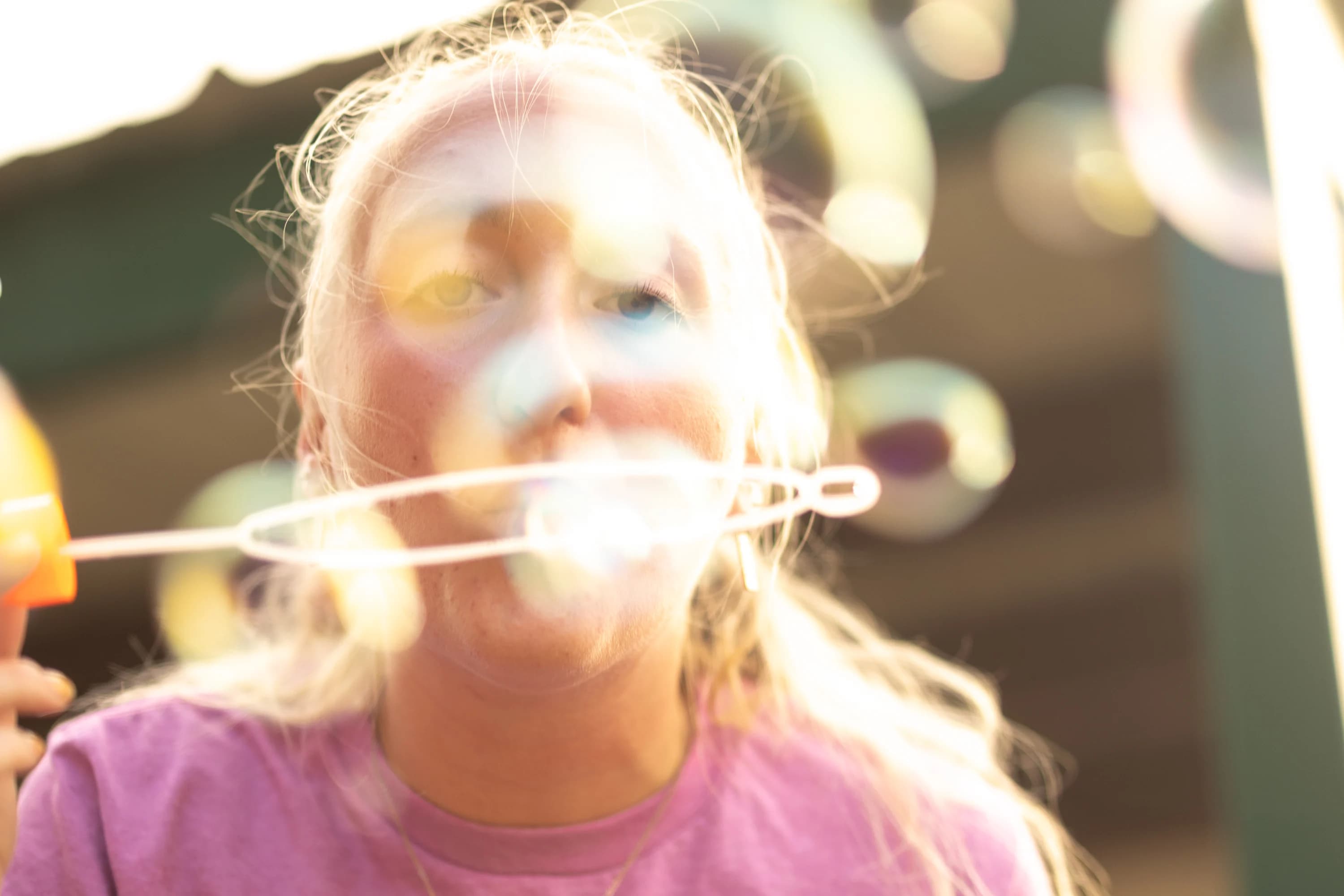 A child blowing bubbles in the sunlight at Citychurch